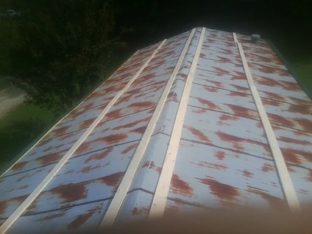 Rusted metal roof panels with new wood purlins before replacement — Storm Damage Roof Repair in Anton by Roofing Brothers