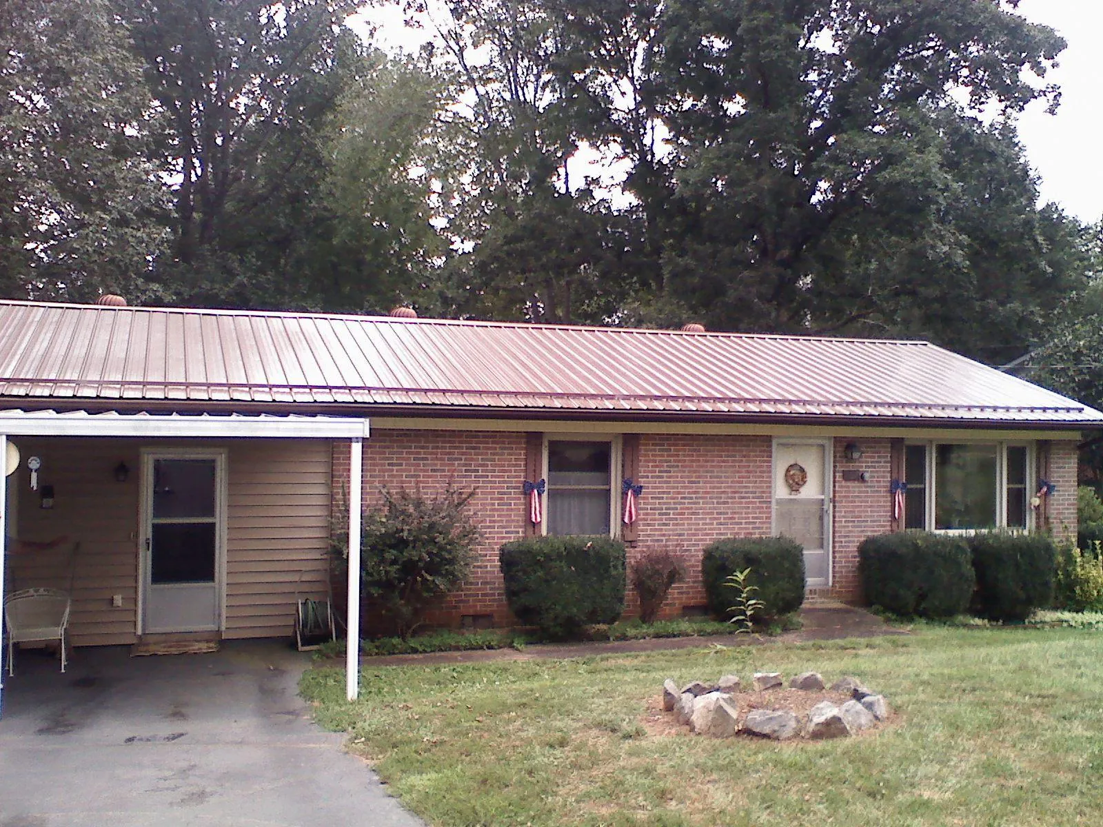 Bronze metal roof and carport on a brick ranch home — Roof Repair work by our crew in Anton