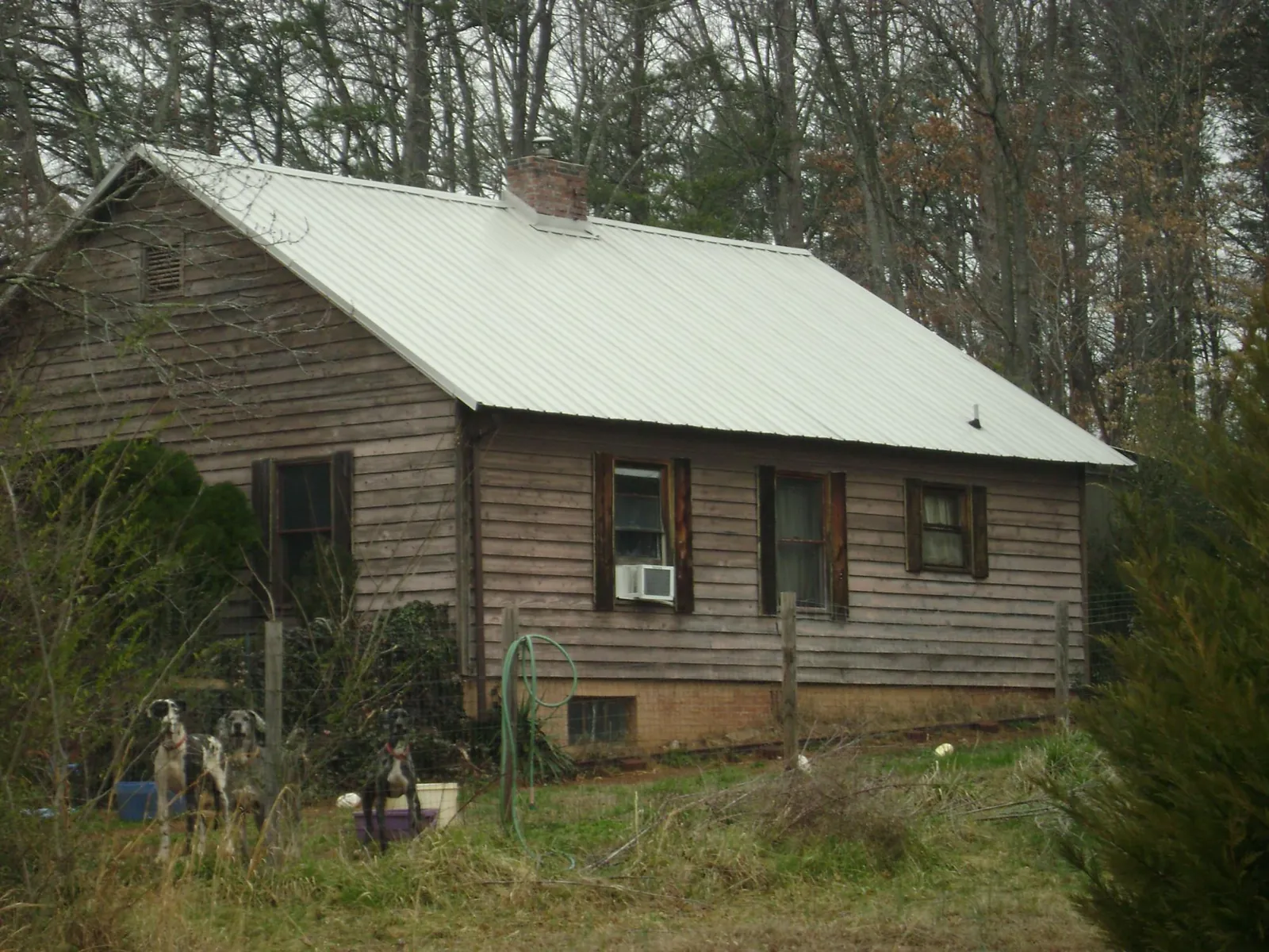 White metal roof on an old wood sided farmhouse, from a Metal Roof Installation job in Anton